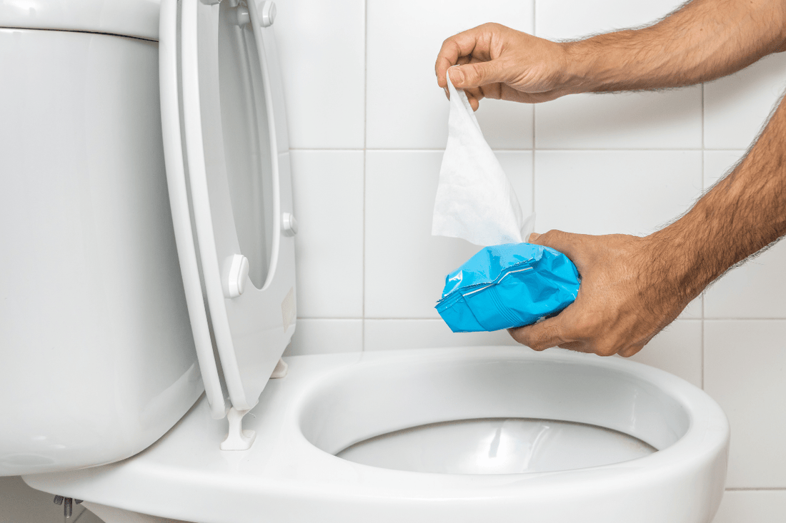 Feuchttücher Toilette: Eine Person hält ein Feuchttuch über eine Toilette – kurz davor, es hineinzuwerfen. 